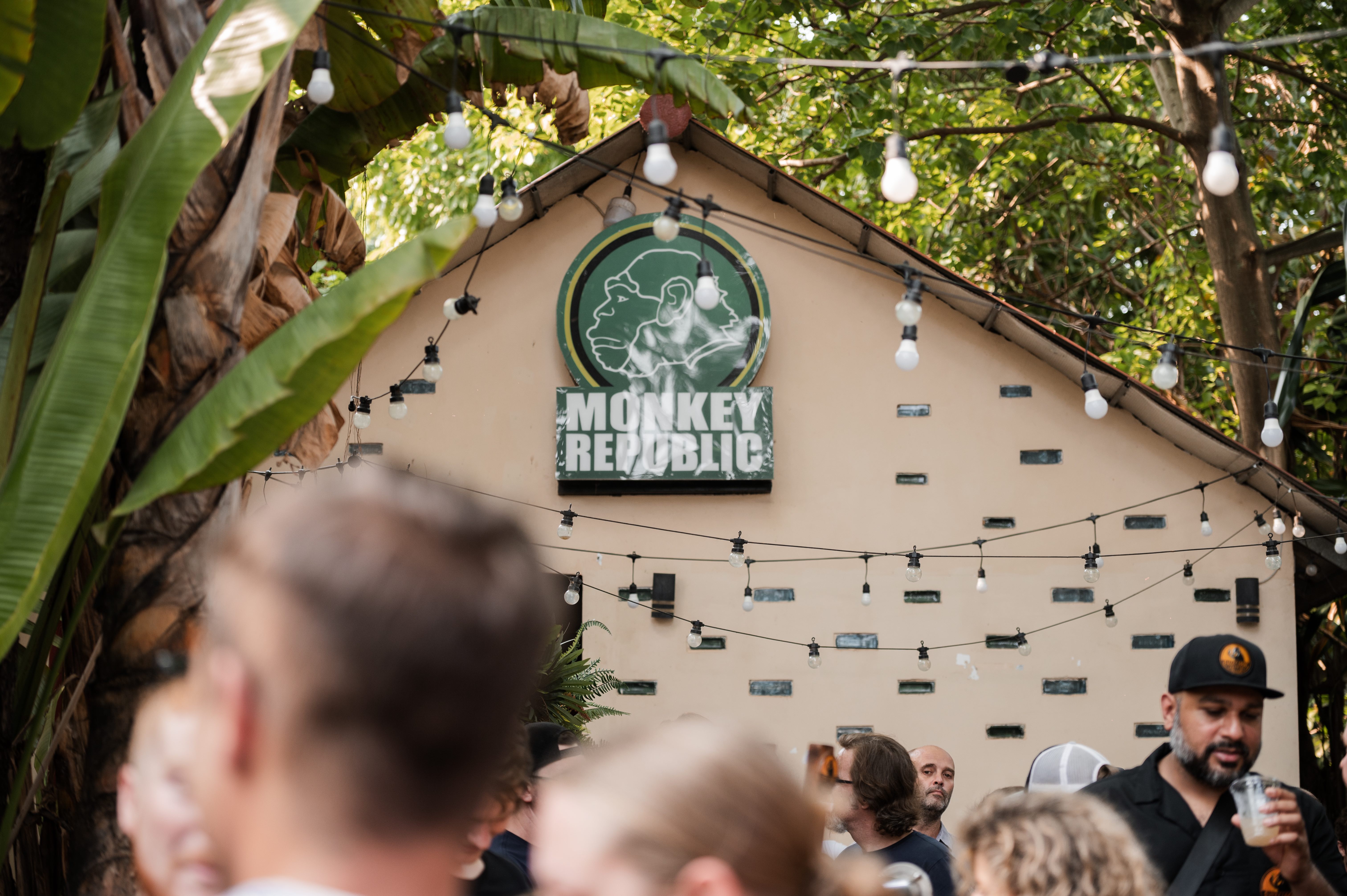 Monkey Republic sign with festive lights and crowd