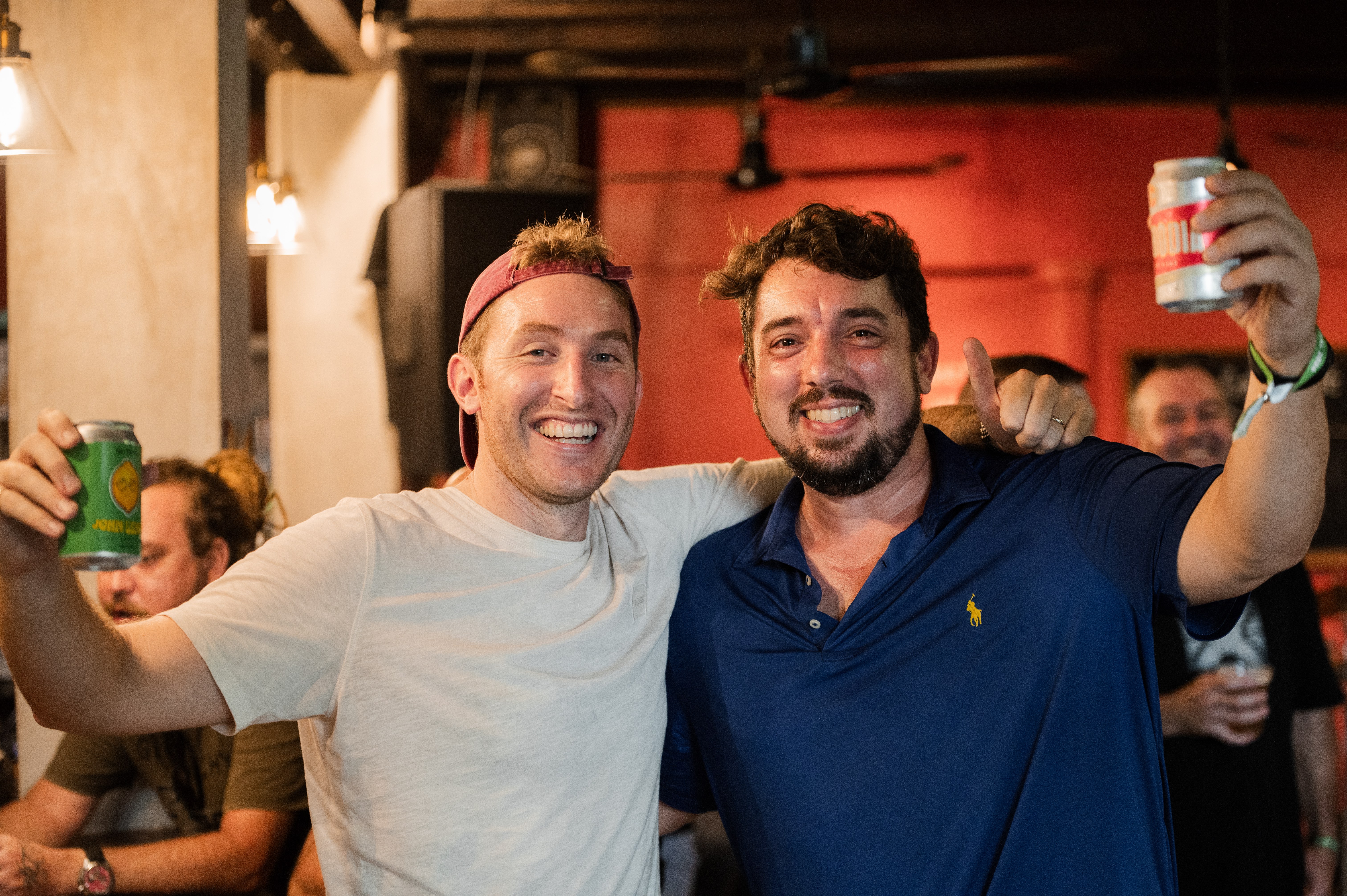 Two friends raising beers and smiling